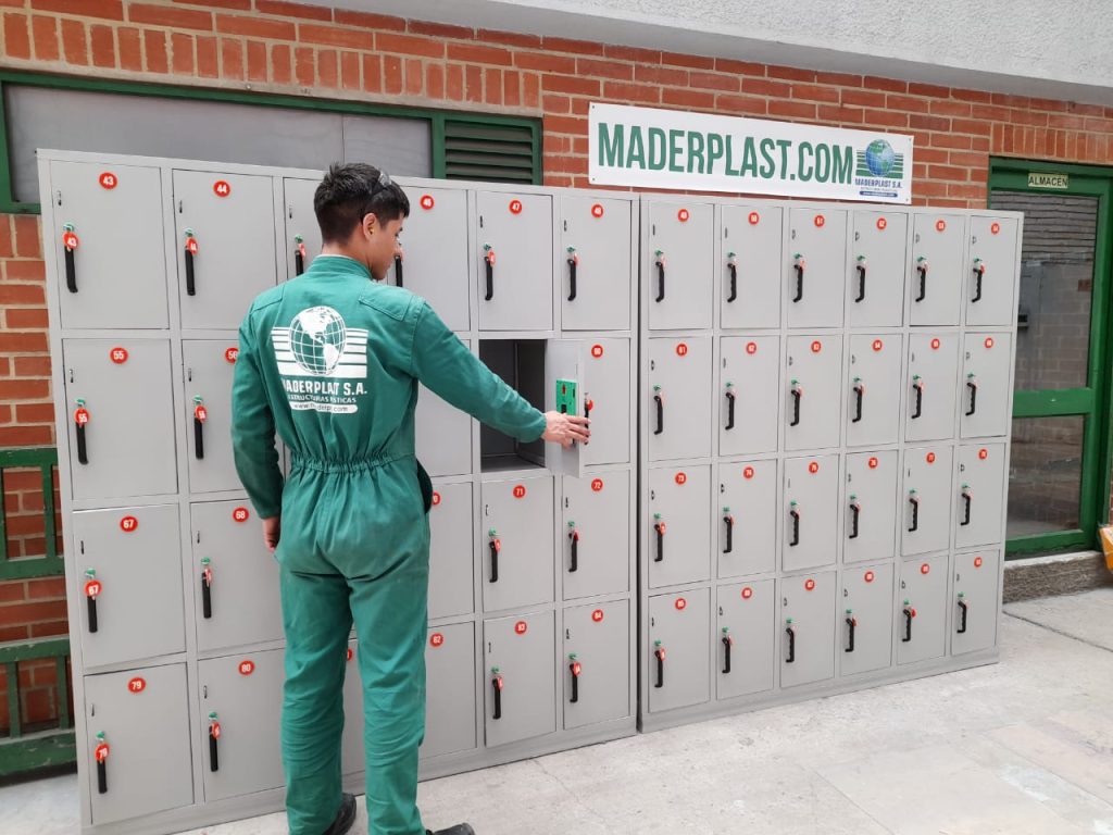 Empleado de Maderplast usando lockers plásticos modulares en polipropileno, instalados en zona común para almacenamiento seguro de objetos personales.