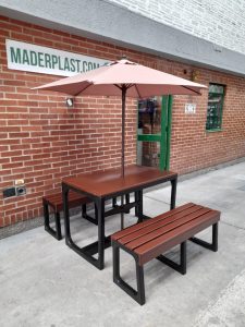 Mesa de comedor exterior con sombrilla, fabricada en polipropileno reforzado, ideal para áreas de descanso en entornos industriales o institucionales.