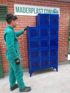 Empleado manipulando un locker plástico azul de polipropileno con compartimientos individuales, ideal para almacenamiento seguro en ambientes industriales.